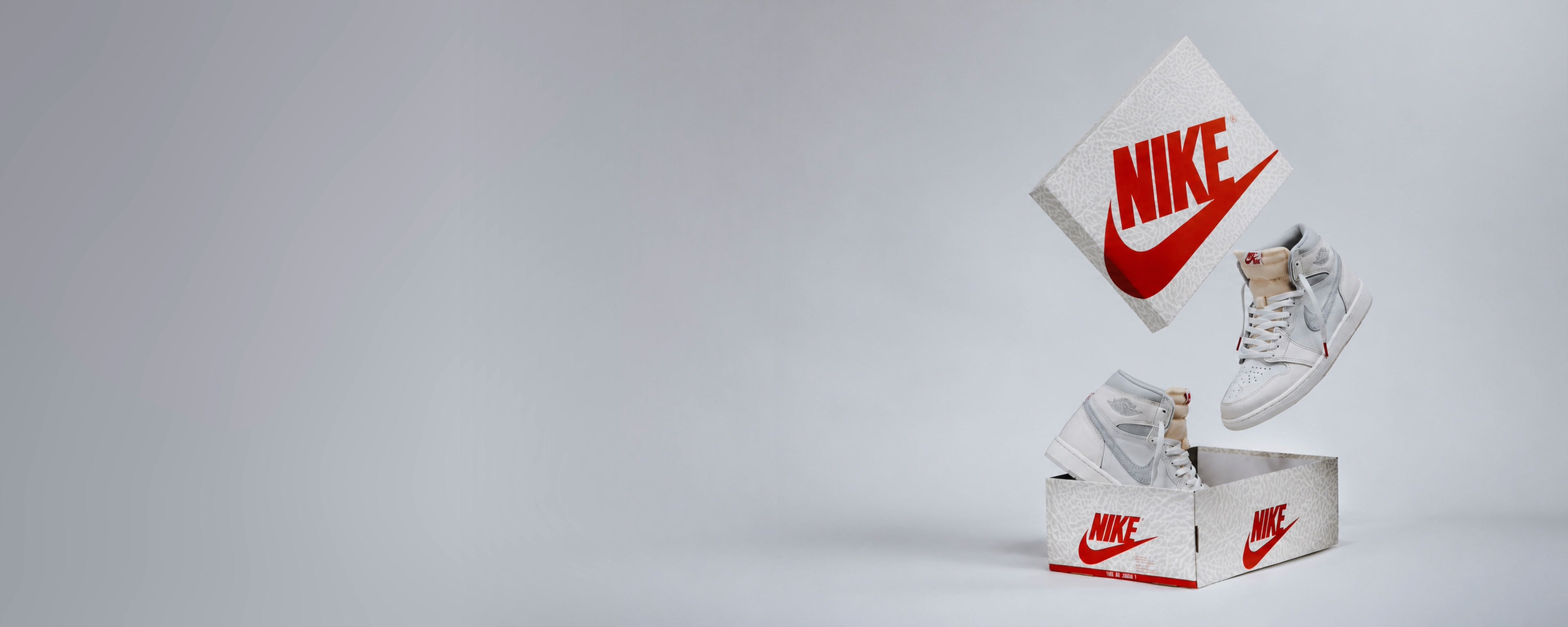 White and grey Air Jordan 1 sneakers suspended with Nike shoeboxes