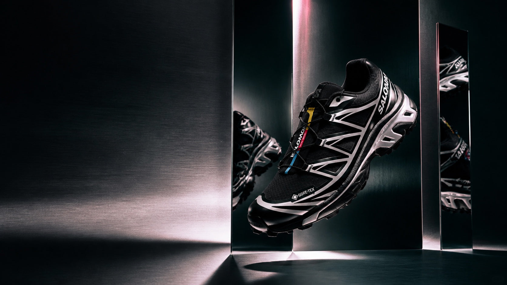 Salomon XT-6 GORE-TEX Black Silver suspended in a mirrored metal installation